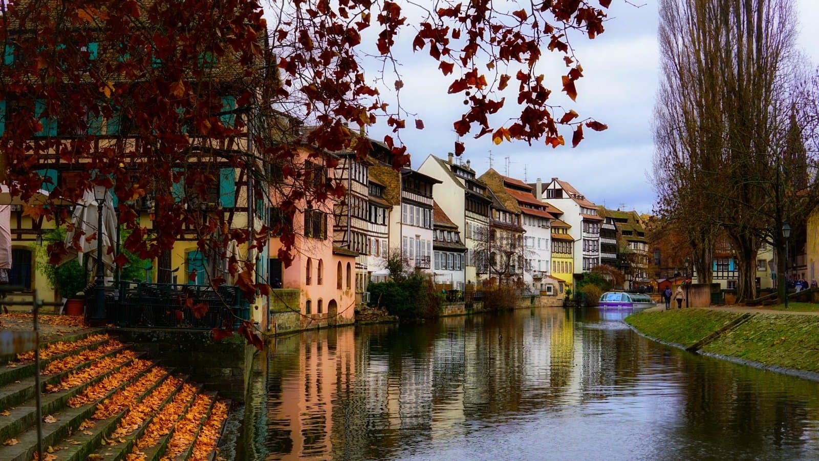 Colorful half-timbered houses reflecting in a canal in Strasbourg during autumn